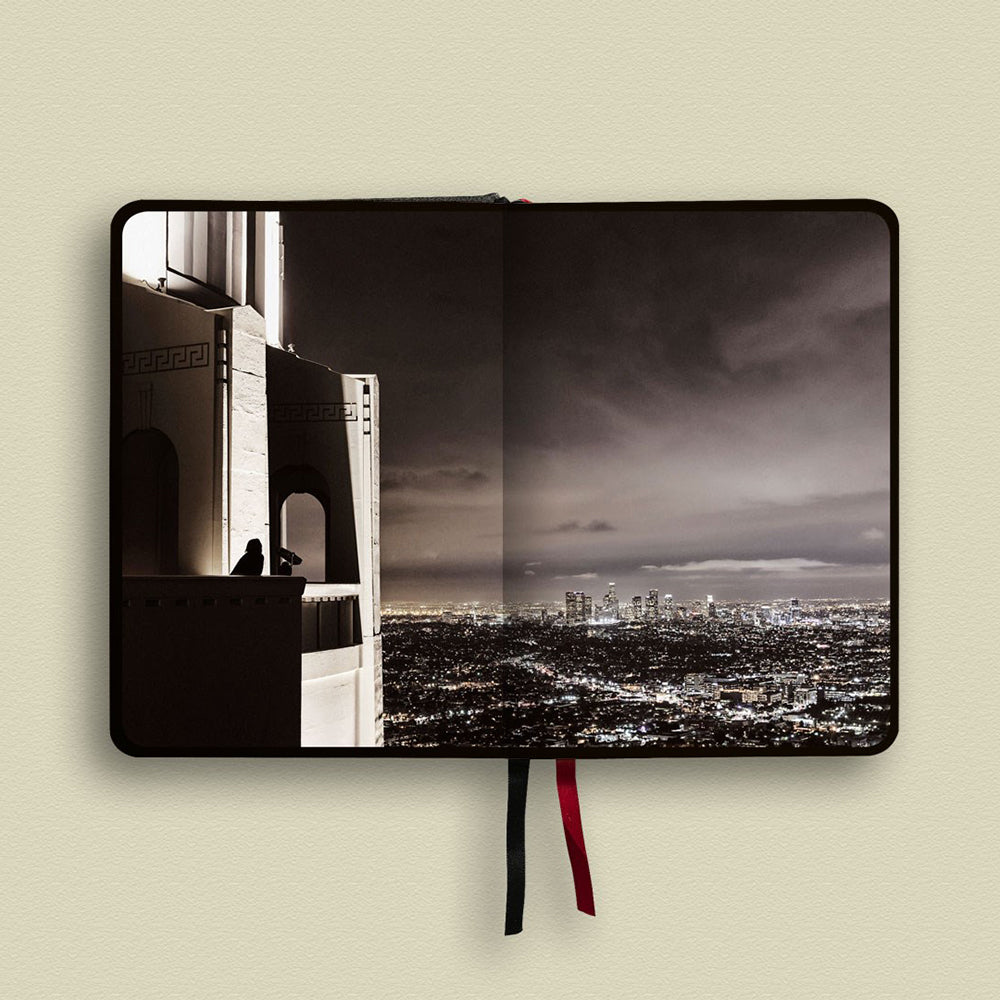 Notebook with a cityscape design on the cover against a beige background