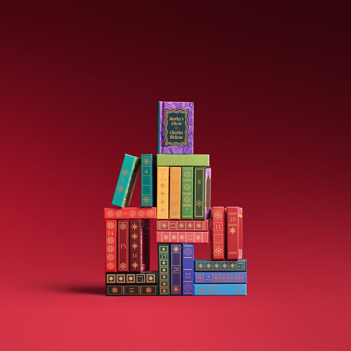 Colorful books stacked on top of each other against a red background 