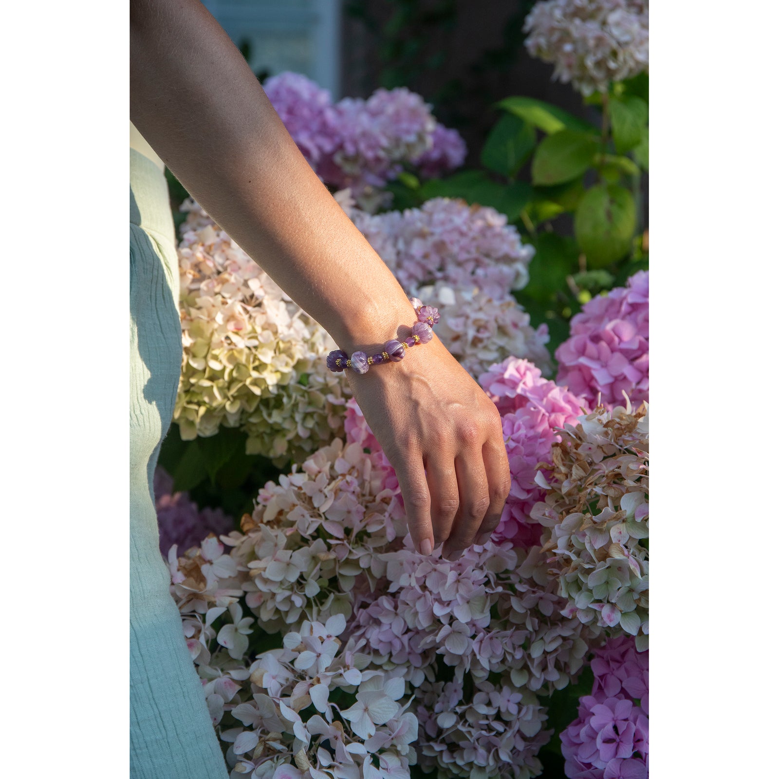 Purple beaded bracelet with gold accents on a white background