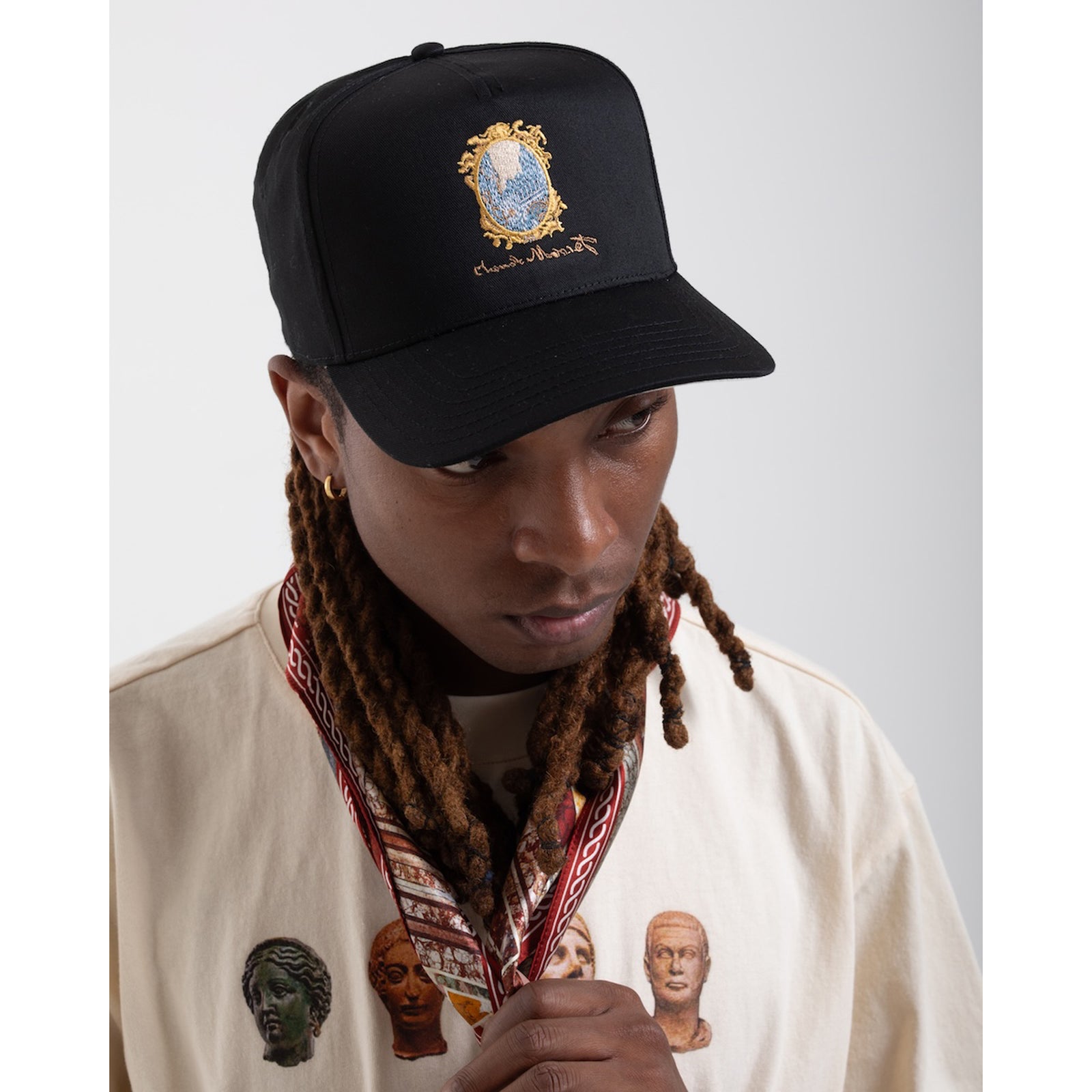 Black cap with embroidered design on a white background