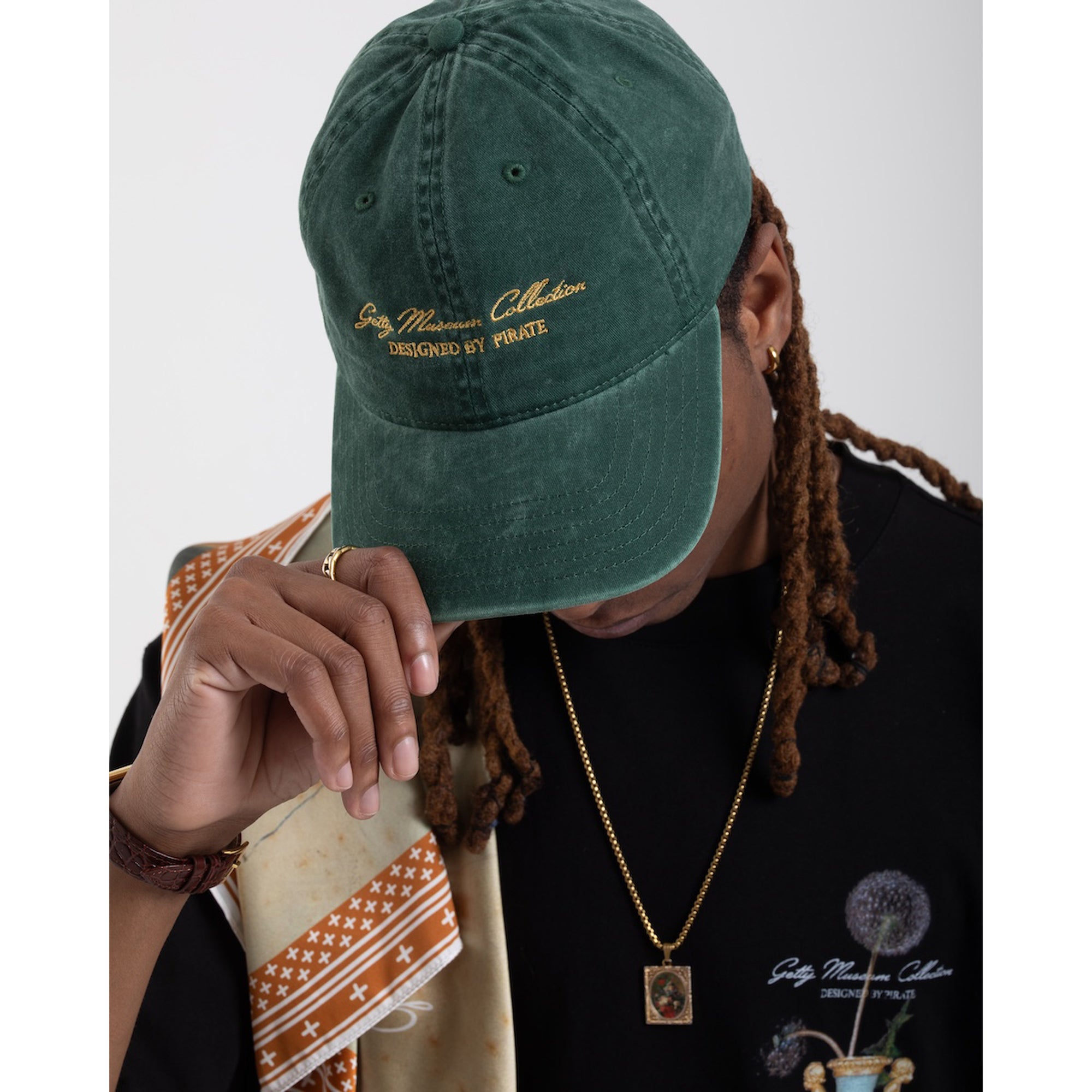 Green cap with embroidered text on a white background