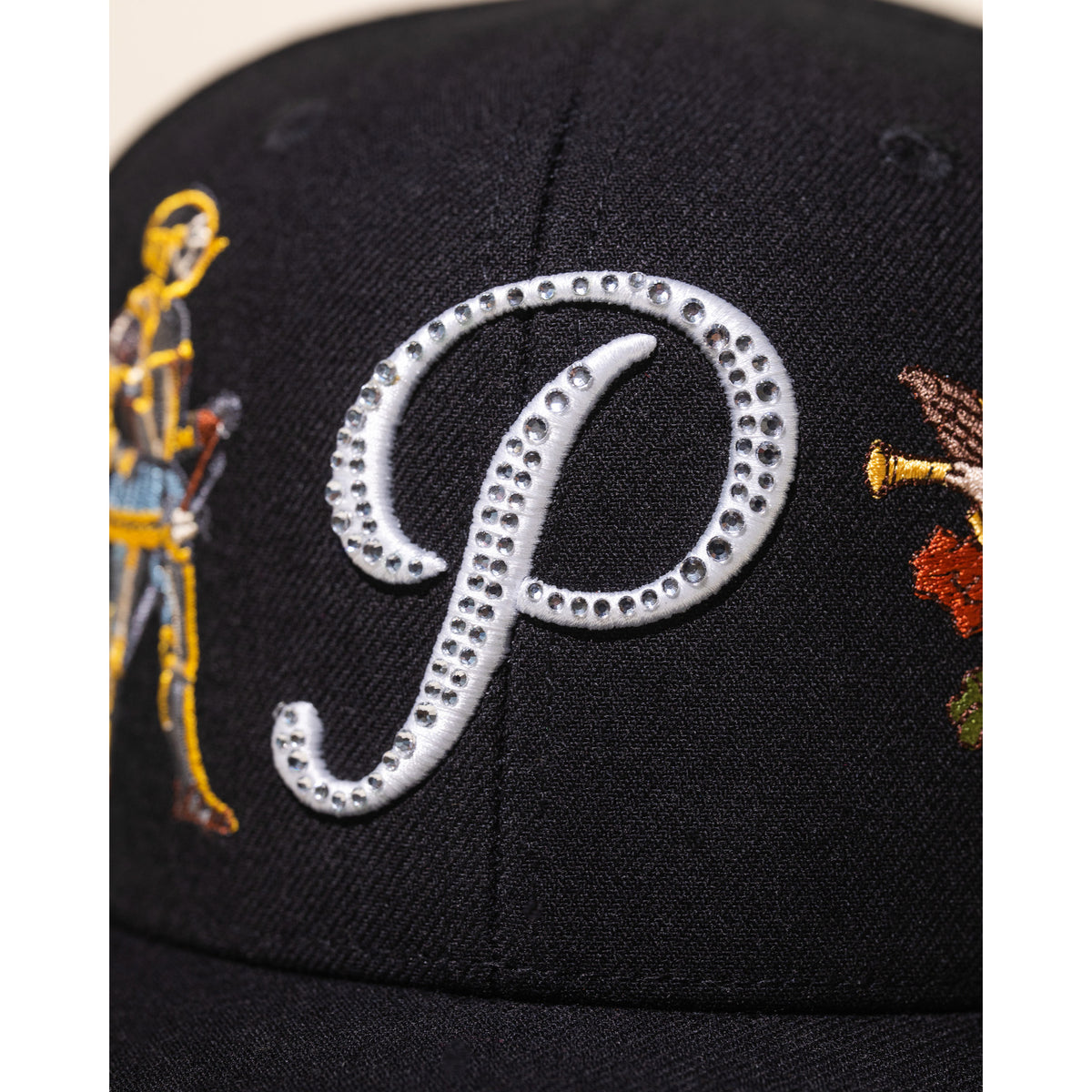 Black cap with decorative elements and a large 'P' on a white background