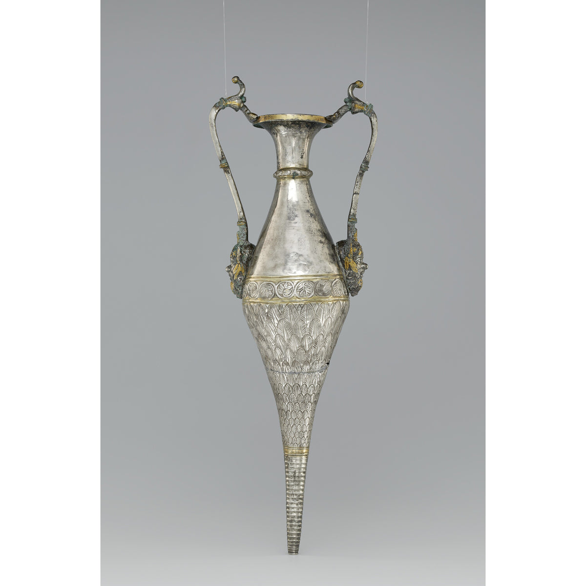 Decorative silver vase with intricate designs on a gray background