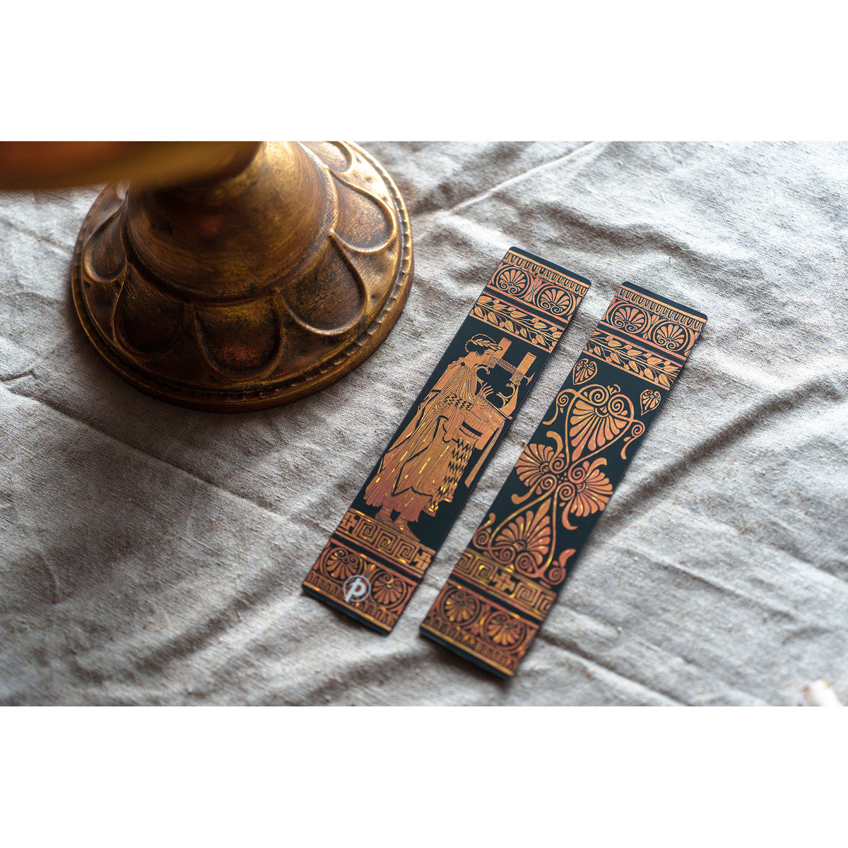 Two decorative bookmarks with intricate designs on a textured surface.