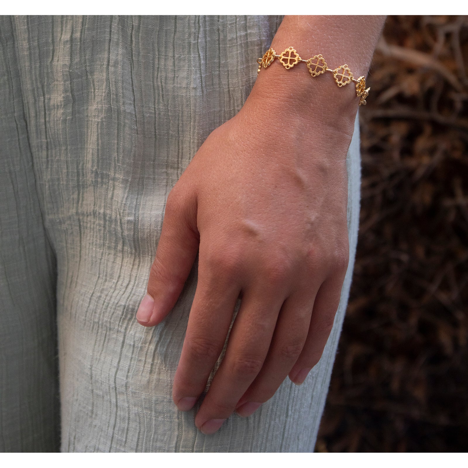 Gold bracelet with intricate designs on a white background