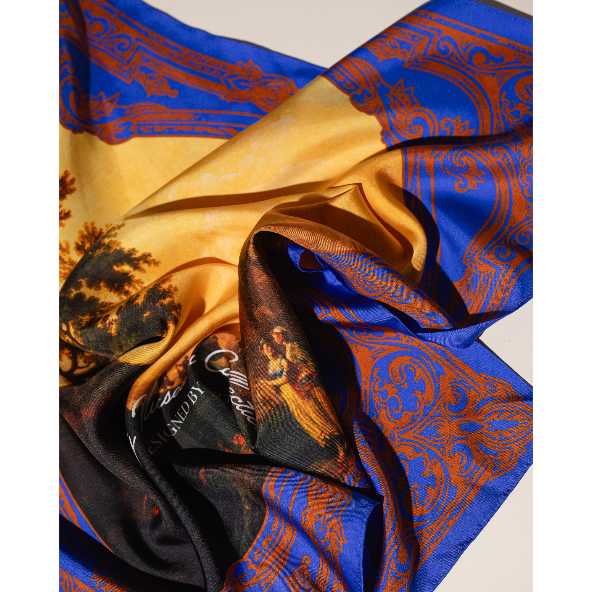 Silk bandana with a scenic design and ornate blue border on a white background