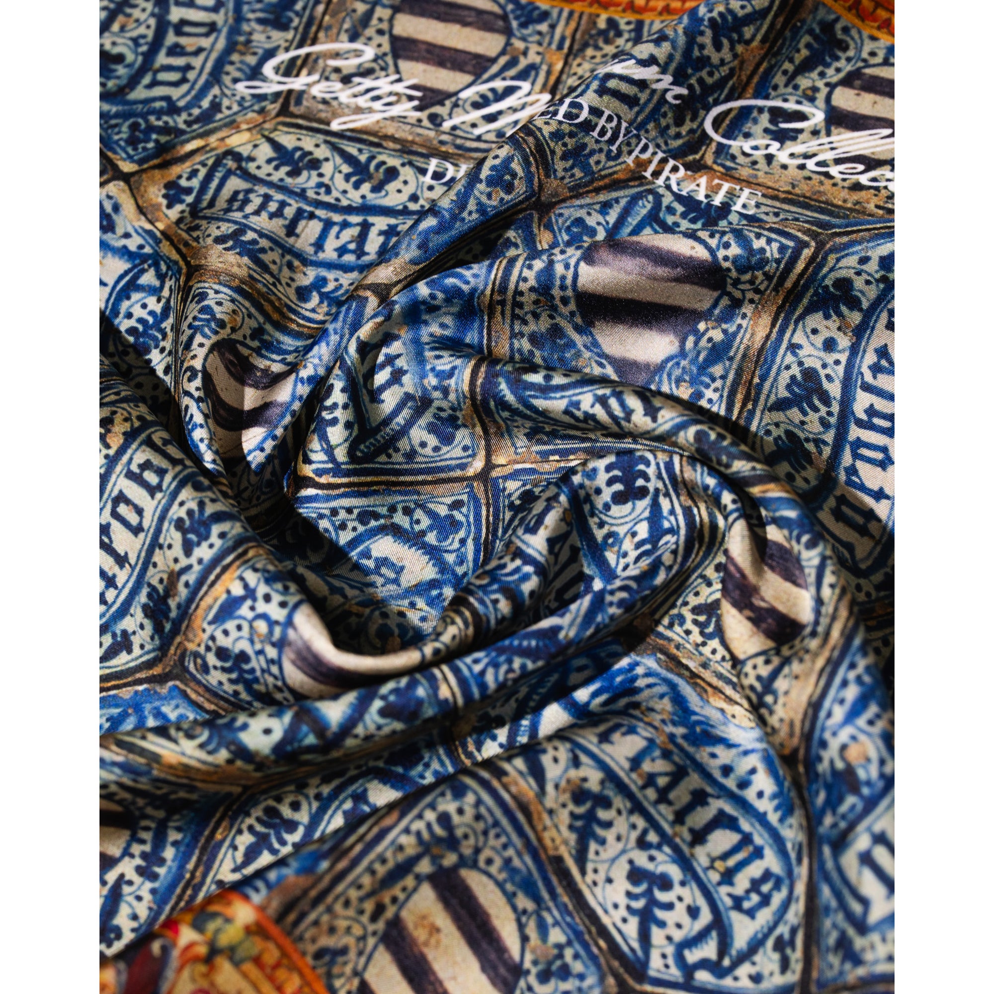 Silk bandana with blue geometric pattern and colorful border on a white background