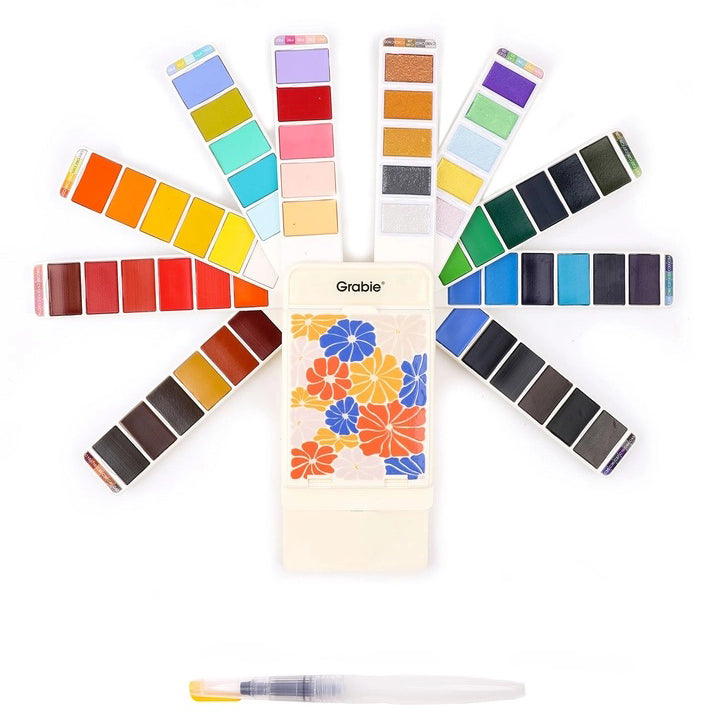 Set of watercolor paint pans with a floral design case on a white background