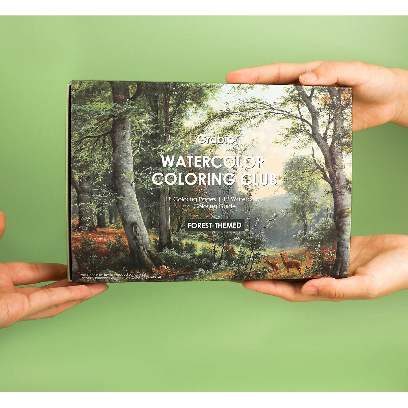 Coloring book titled 'Watercolor Coloring Club' with a forest-themed cover held by hands against a green background