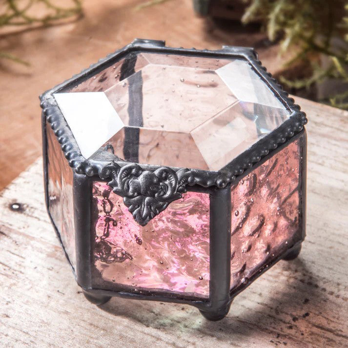 Decorative pink glass box with metal hardware in the shape of a hexagon