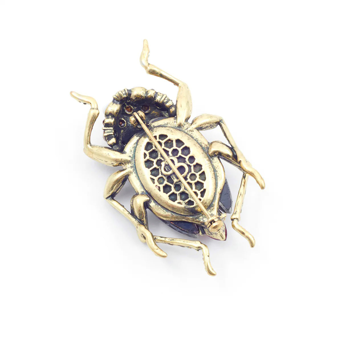 Gold beetle-shaped brooch on a white background