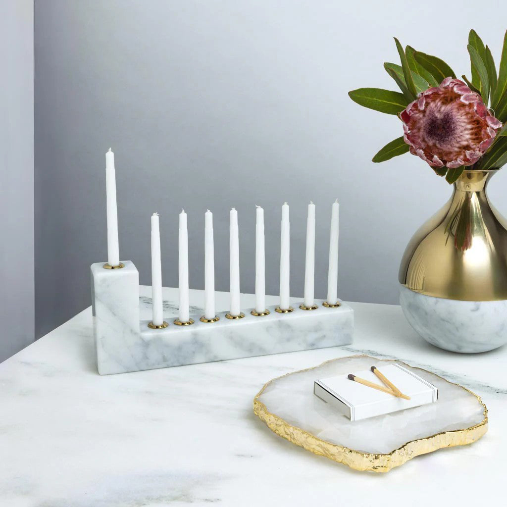 Marble-patterned candle holder with gold accents on a white background
