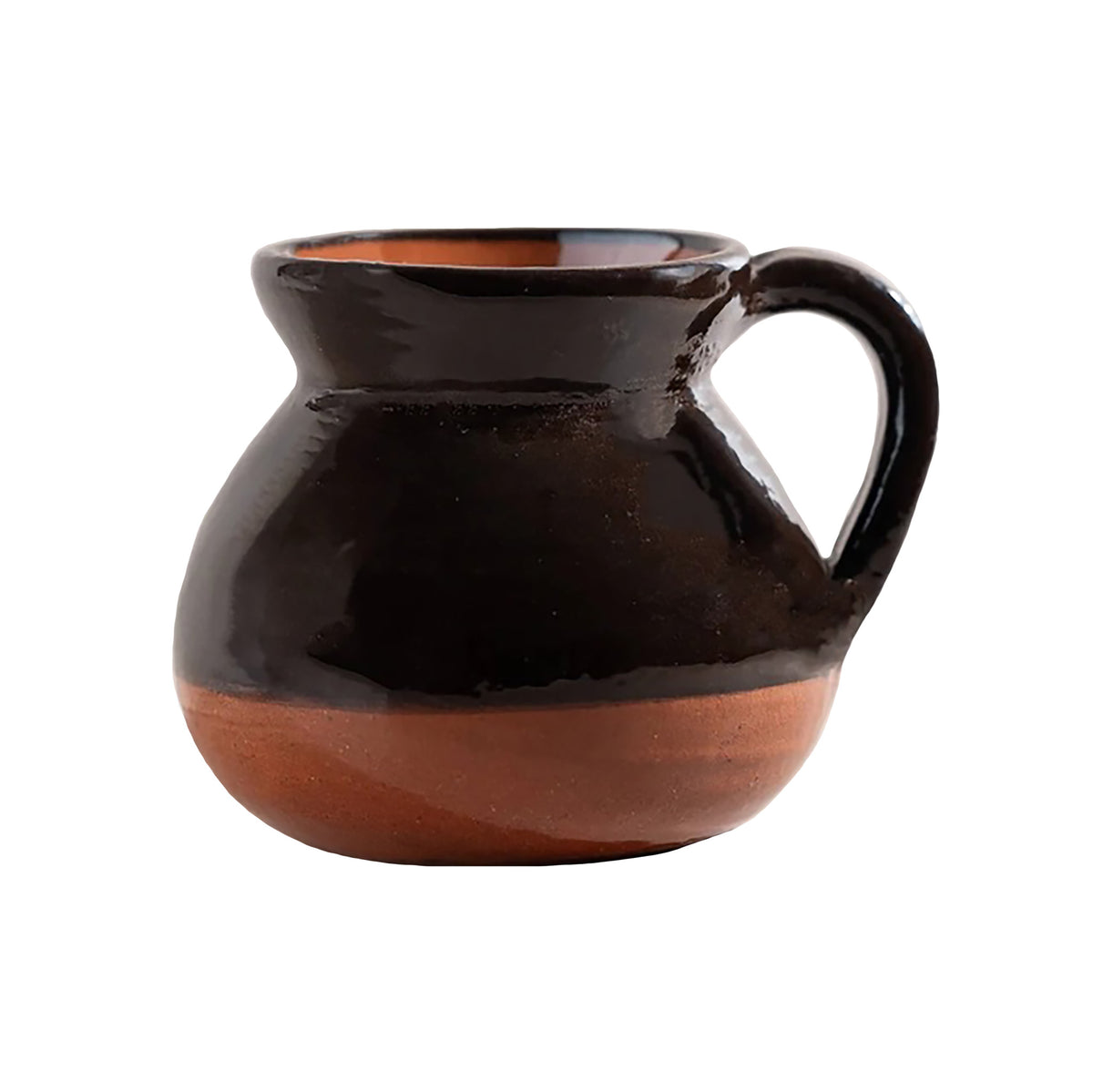 A small handmade ceramic mug with a glossy dark brown glaze on the upper body and a natural terracotta clay finish on the base and interior, featuring a curved handle, set against a plain white background.