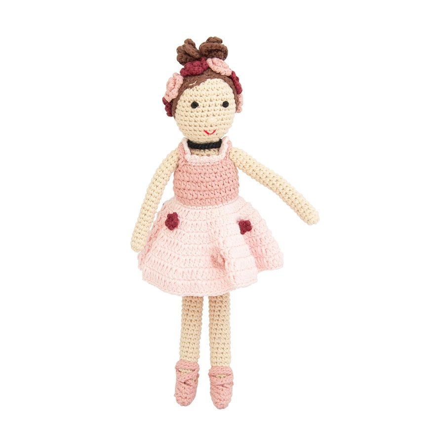 Crocheted doll with a pink dress and brown hair on a white background