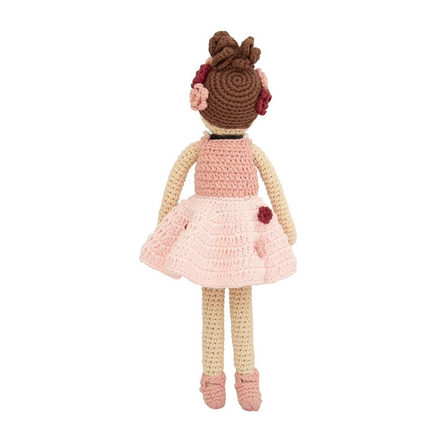 Crocheted doll with a pink dress and brown hair on a white background