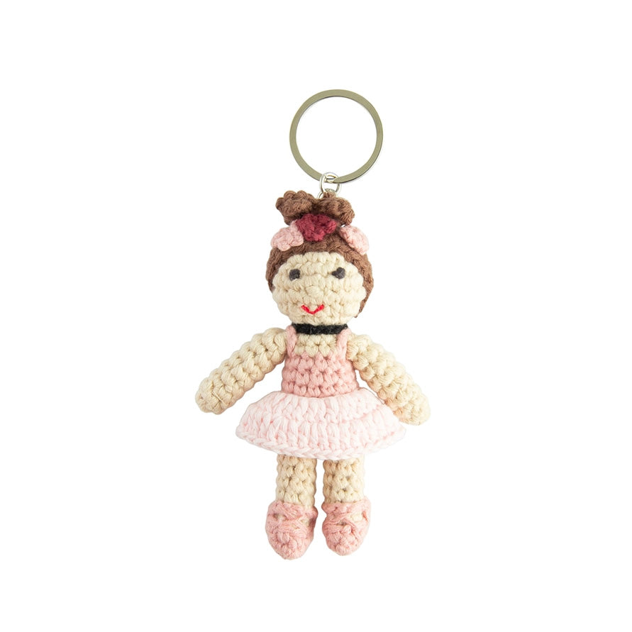 Crocheted doll keychain with a pink dress on a white background