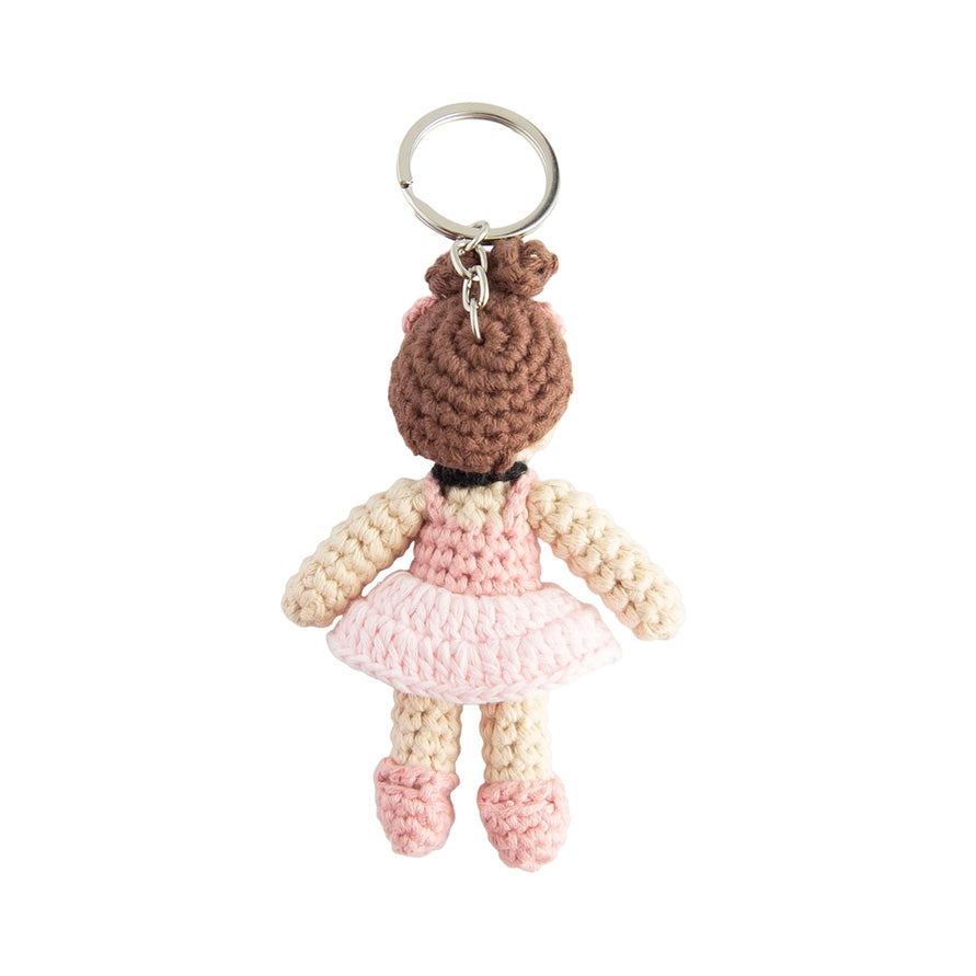 Crocheted doll keychain with a pink dress on a white background