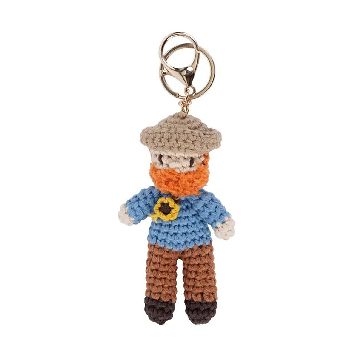 Crocheted keychain of Vincent van Gogh wearing a hat, scarf, and blue shirt with a yellow flower on a white background.