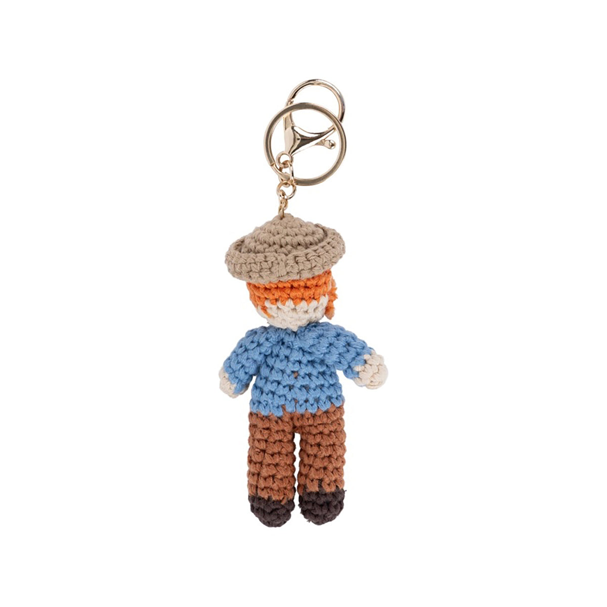 Crocheted keychain of a person wearing a hat and blue shirt on a white background