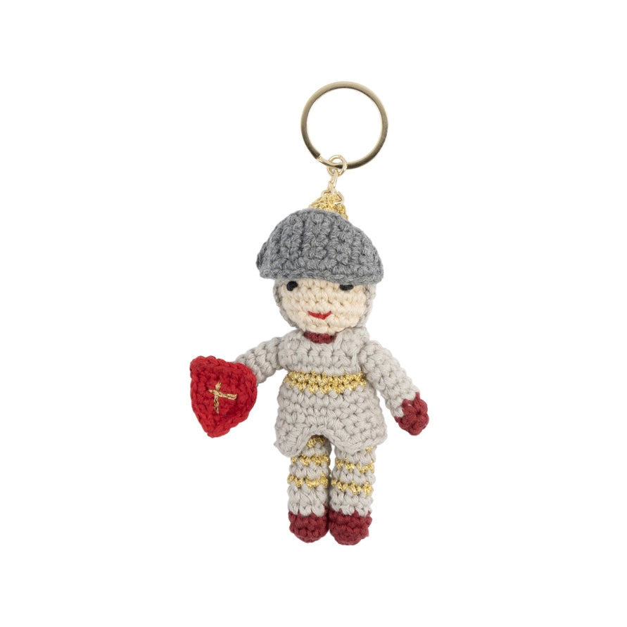 Crocheted knight keychain with a small figure holding a shield, on a white background