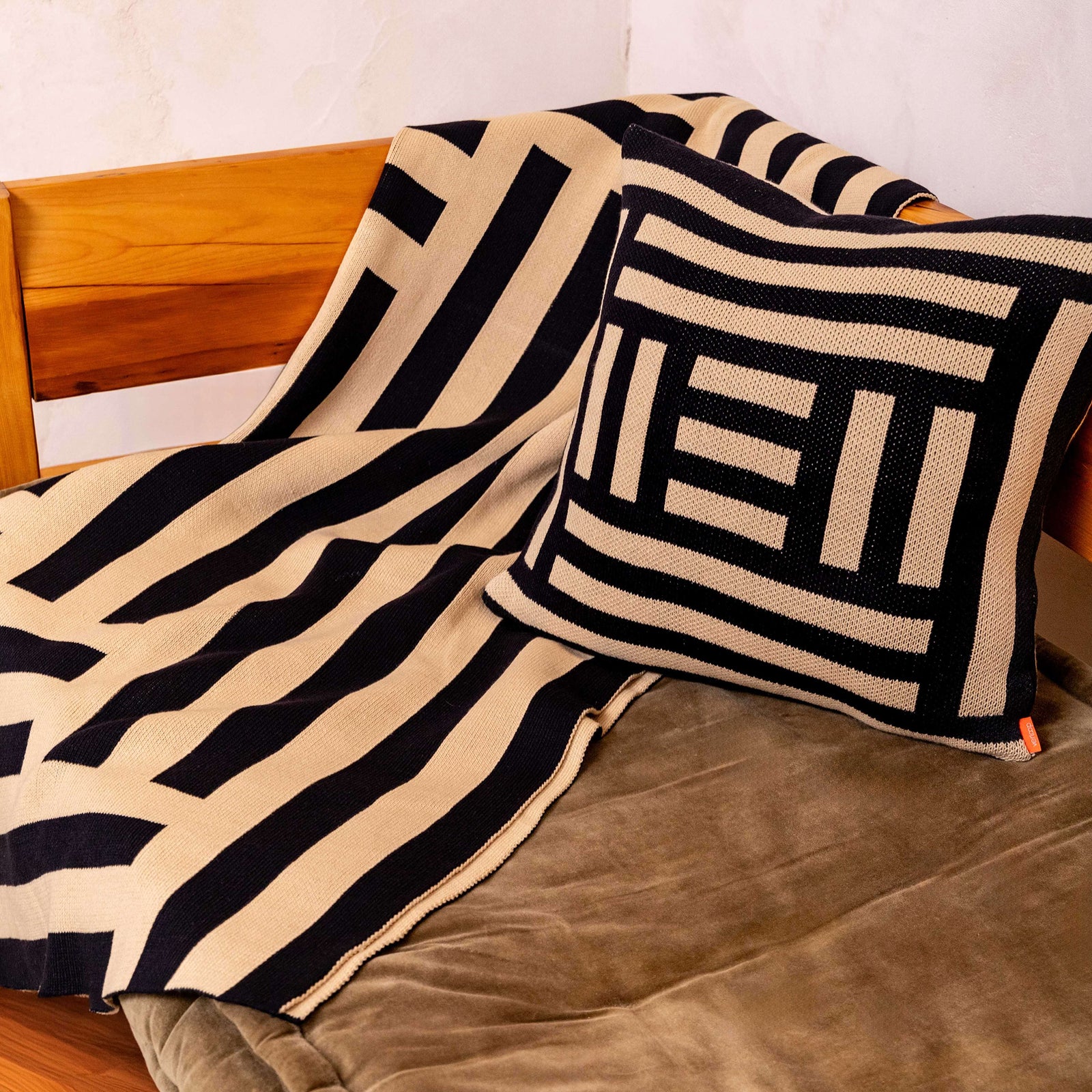 Beige and black geometric patterned blanket on a white background