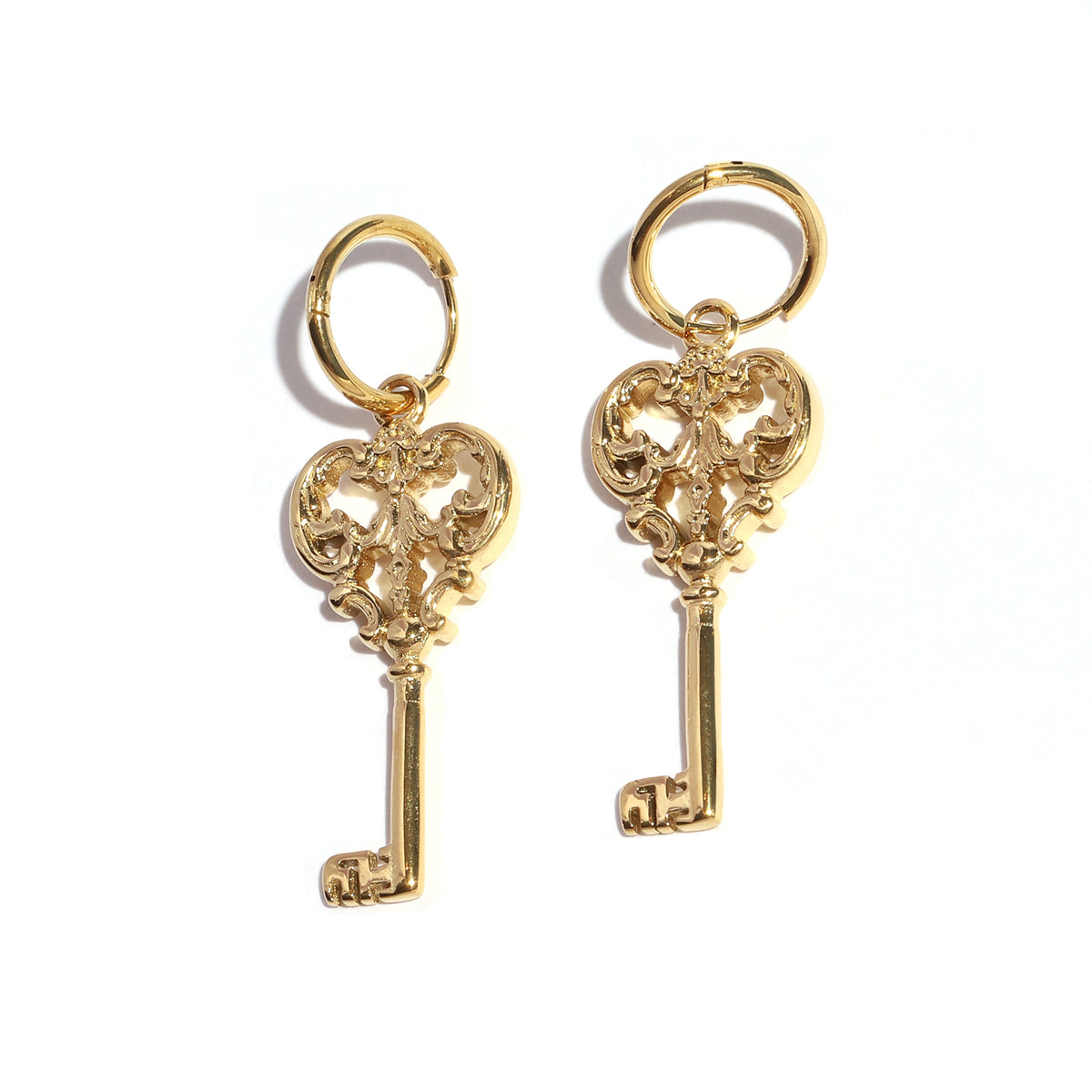 Gold key-shaped earrings on a white background