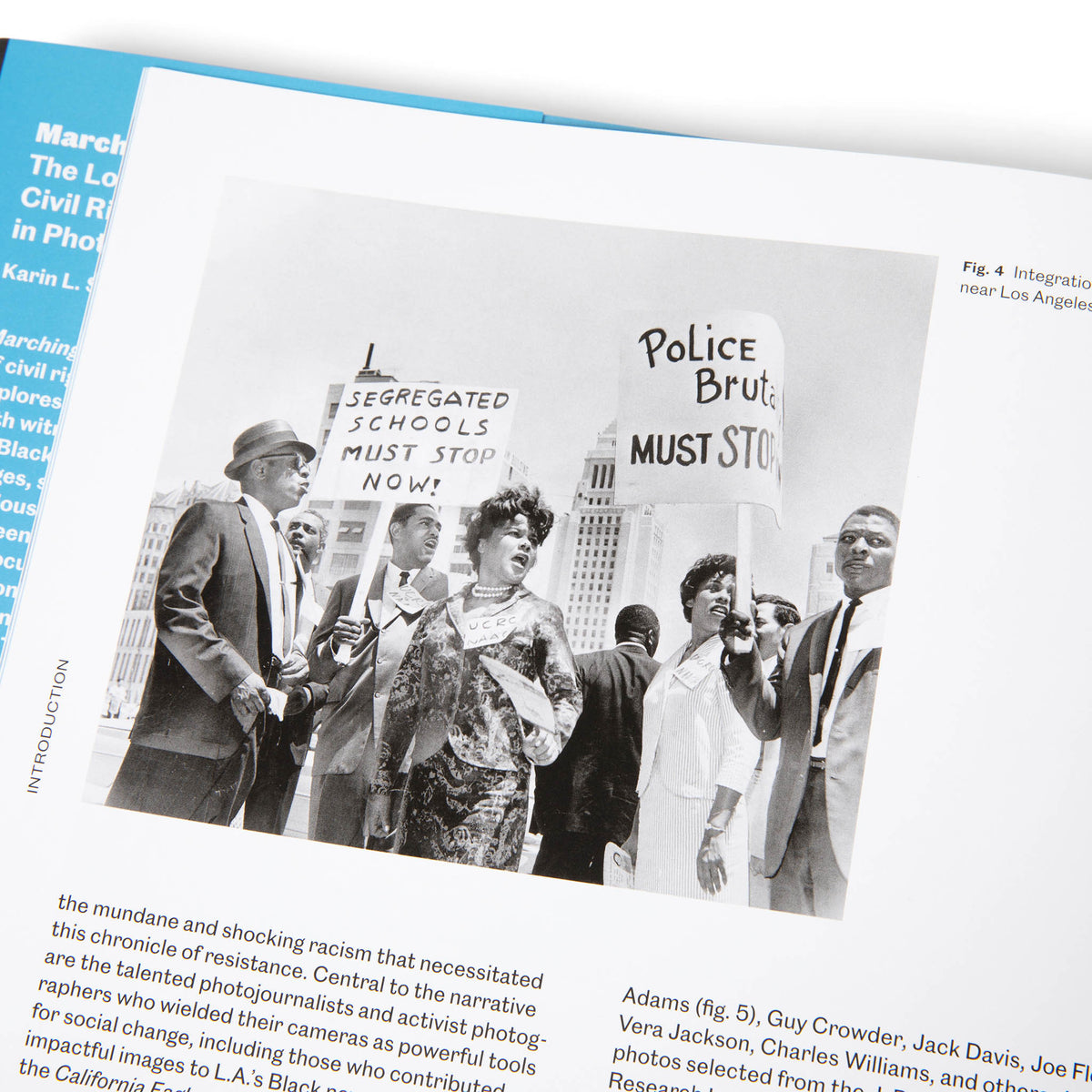 Historical photo of civil rights protesters holding signs with text in a book.