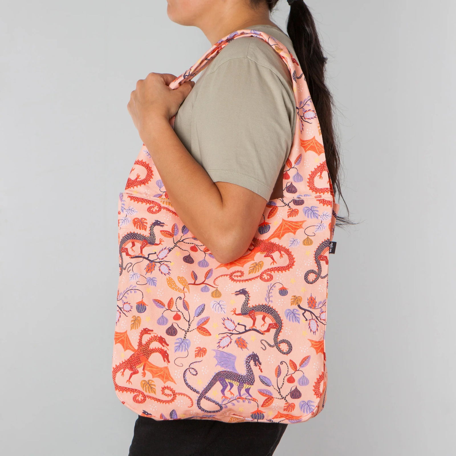 Reusable shopping bag with dragon and floral pattern on a light pink background