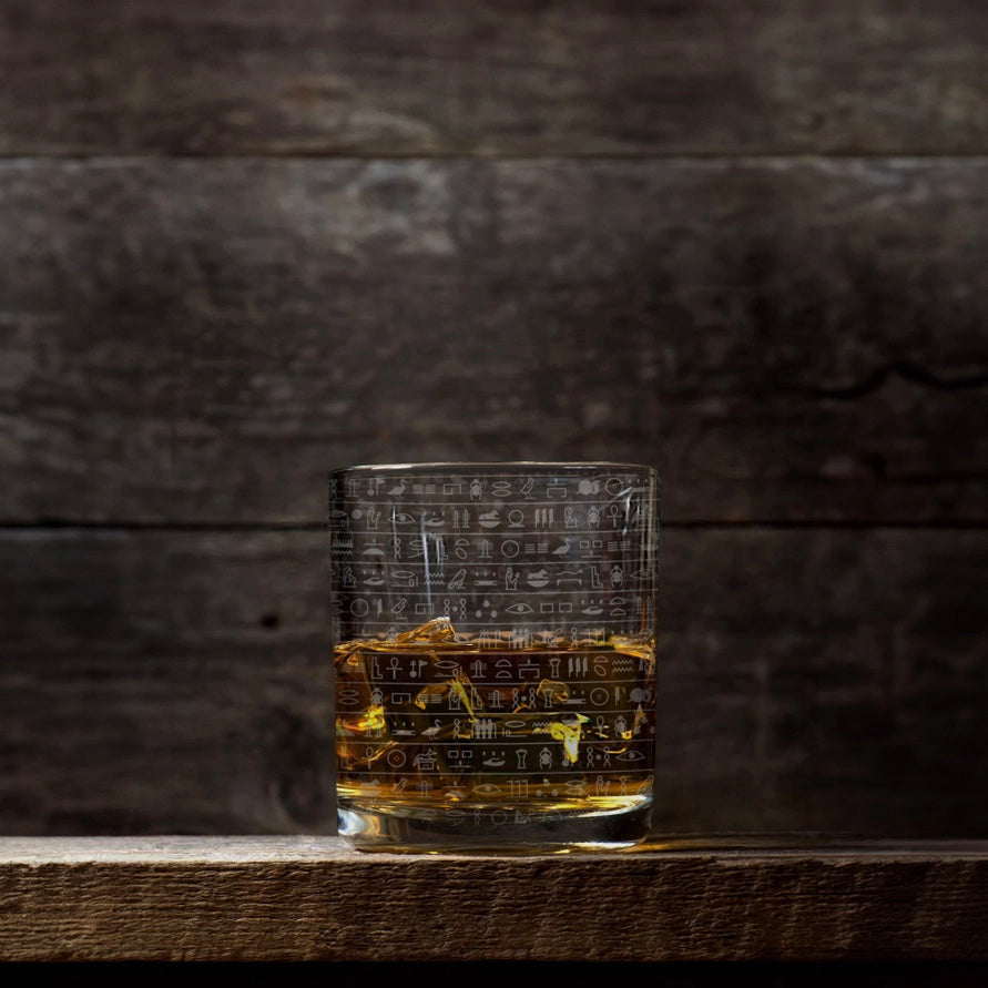 Clear glass with hieroglyphic designs on a white background