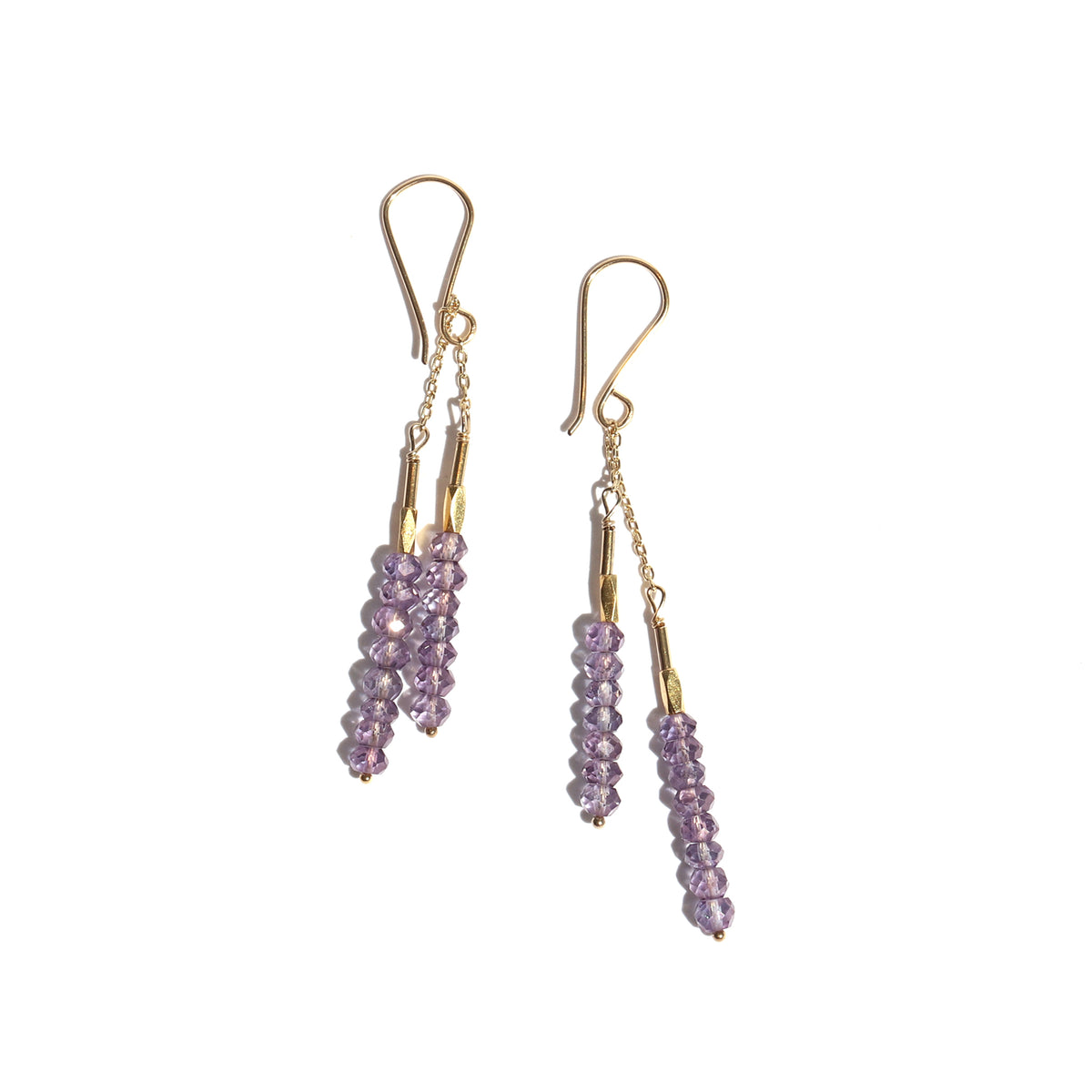 Pair of gold earrings with purple beads on a white background