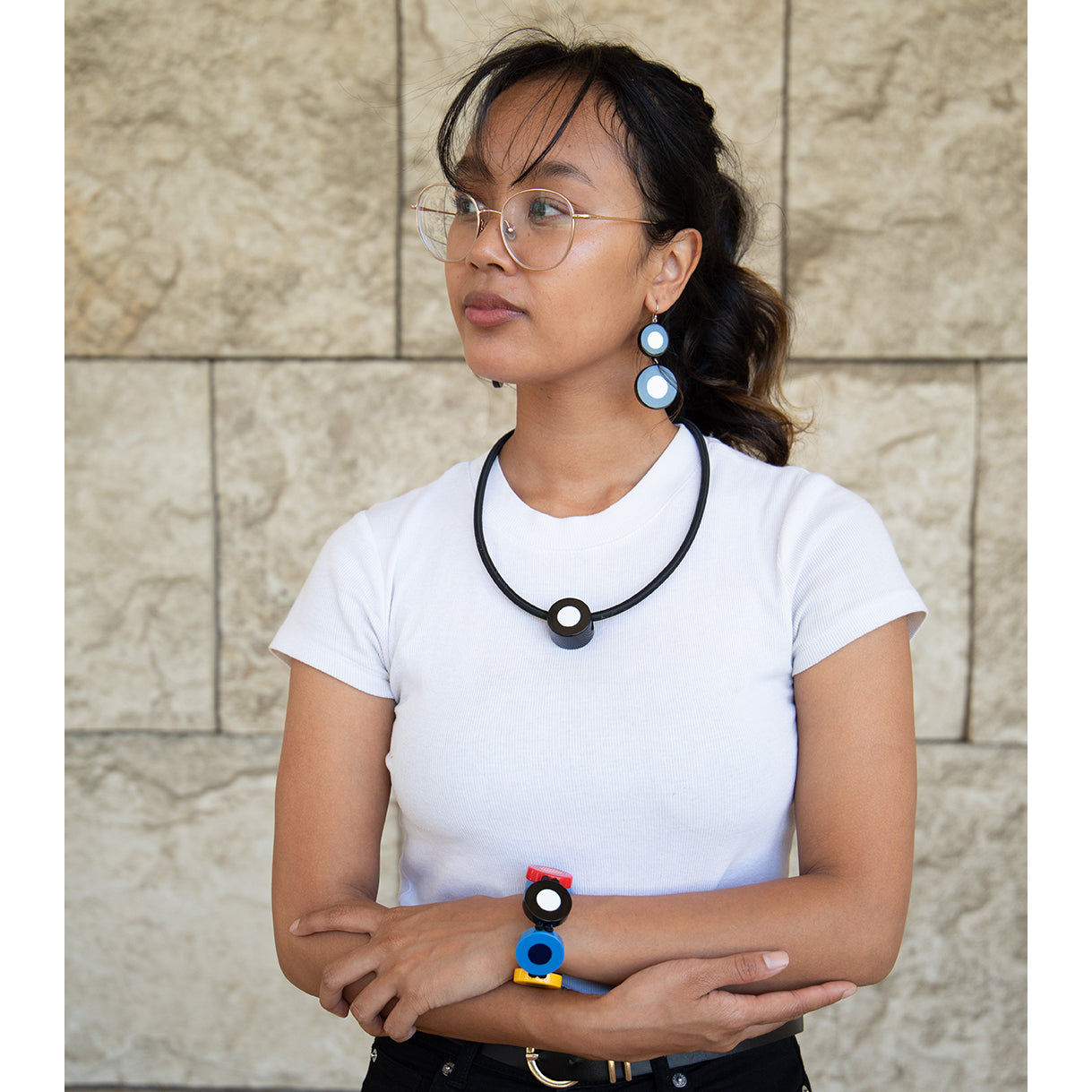 A pair of black and white dot pattern drop earrings made of resin, attached to sterling silver hooks.