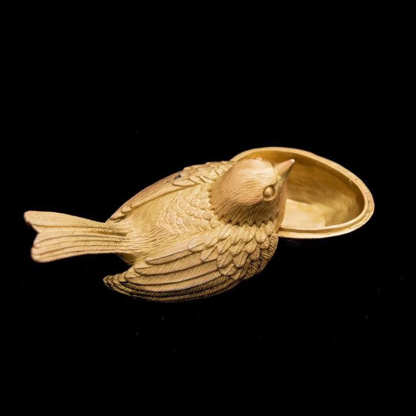 Gold bird-shaped jewelry box on a white background