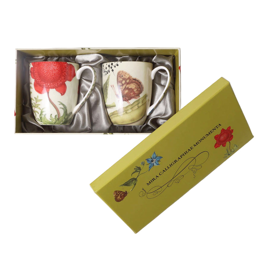 Two decorative mugs in a box with floral and butterfly design, placed on a white background.