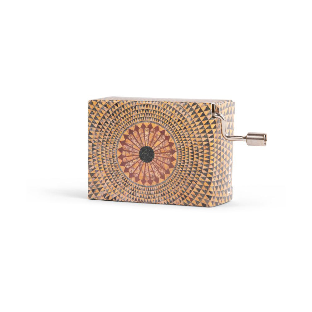 A music box with a geometric pattern resembling a mosaic, featuring a hand crank on the side.