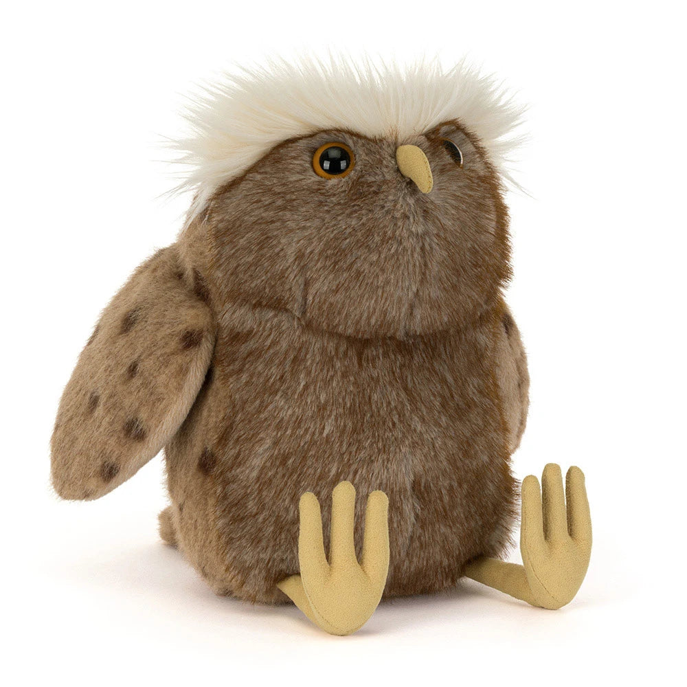 A brown plush owl toy with a fluffy white crest on its head, spotted brown wings, and pale yellow feet and beak, photographed on a clean white background.