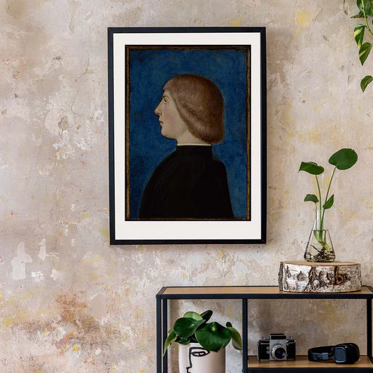 Framed portrait of a person against a textured wall with decorative items on a shelf below.