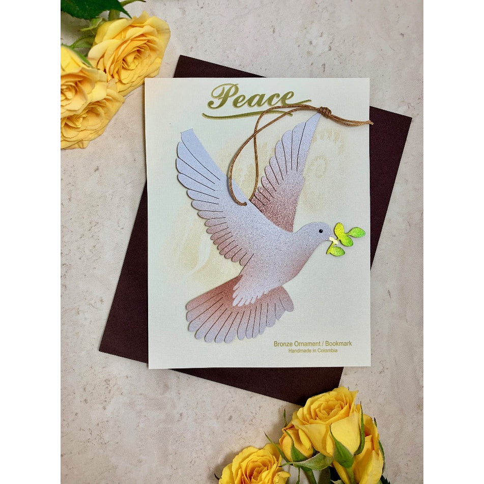 A bronze-colored paper-thin sheet ornament in the shape of a dove with a olive branch