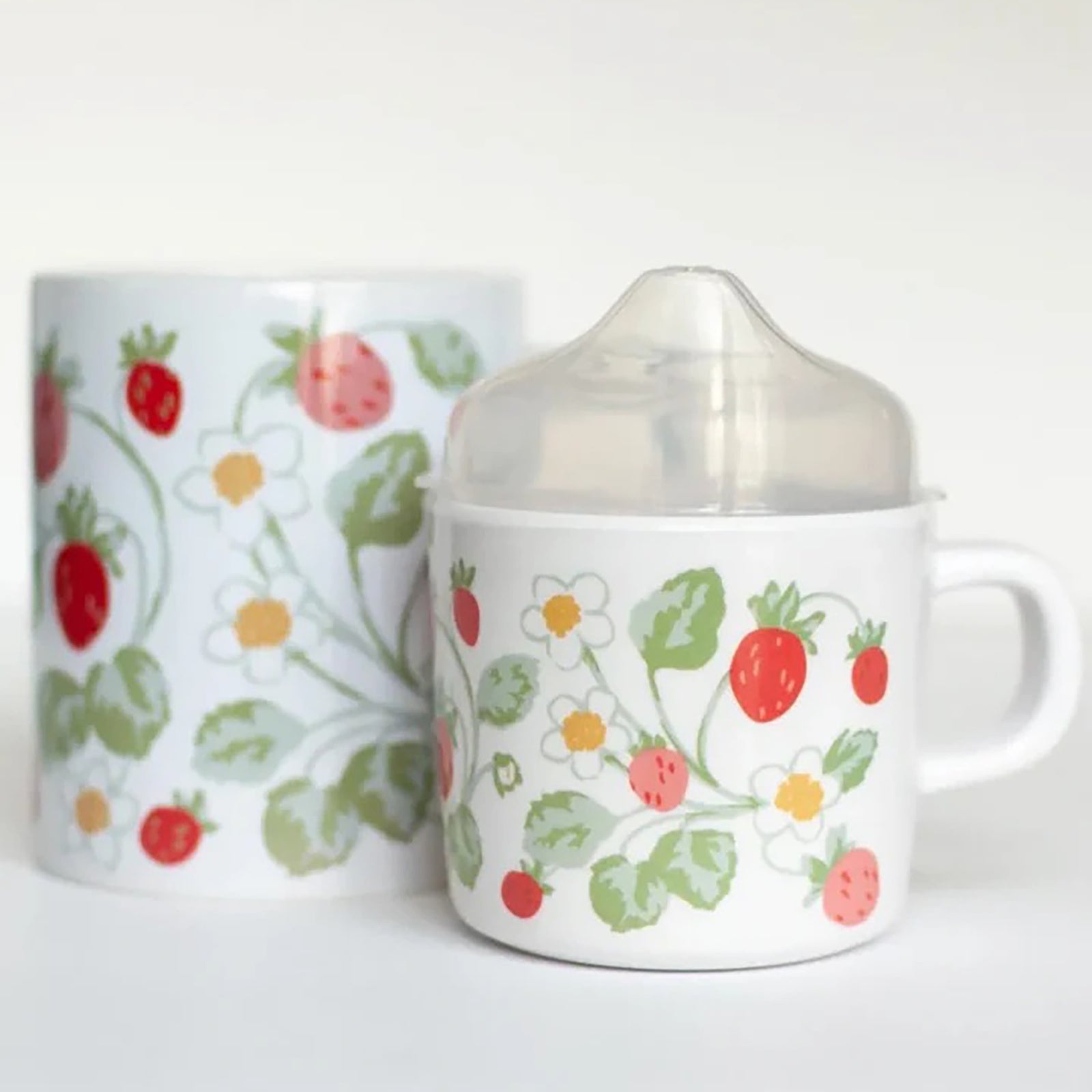 Two mugs with strawberry pattern on a white background