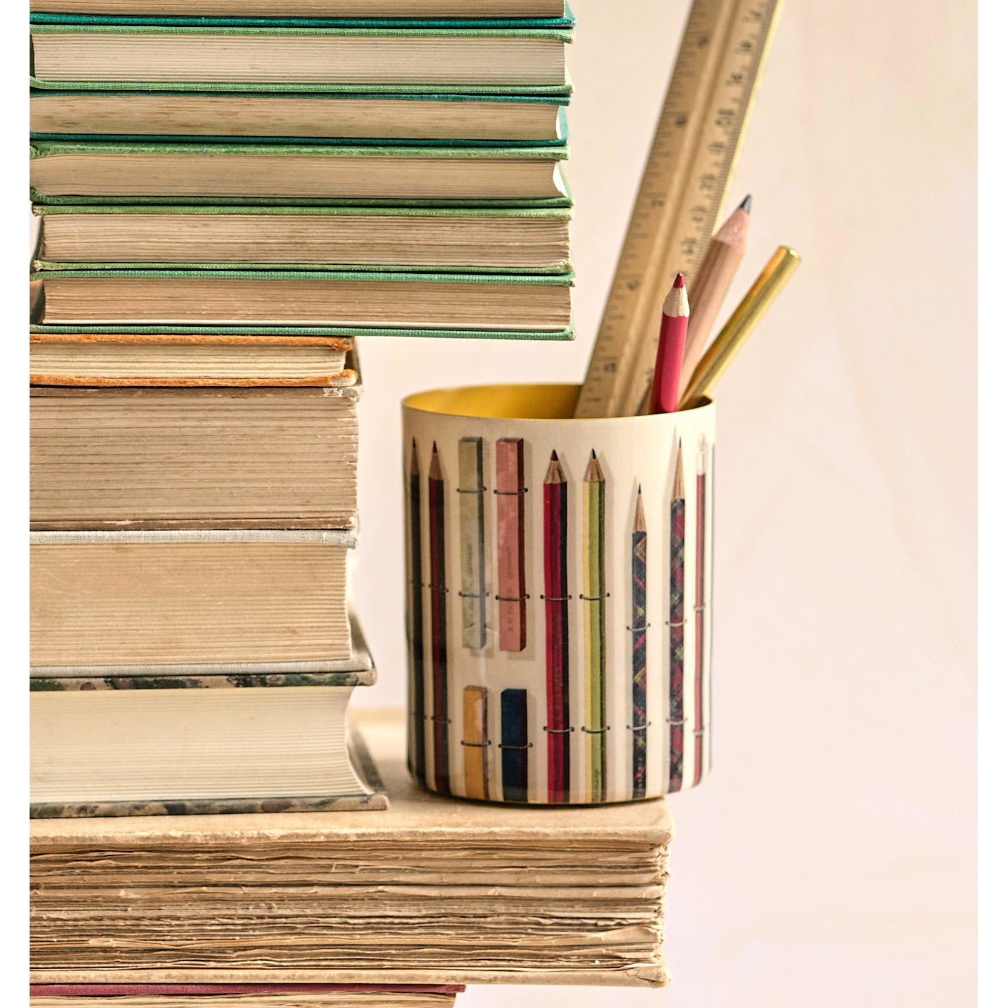 Cylindrical container with colorful pencil design on a white background