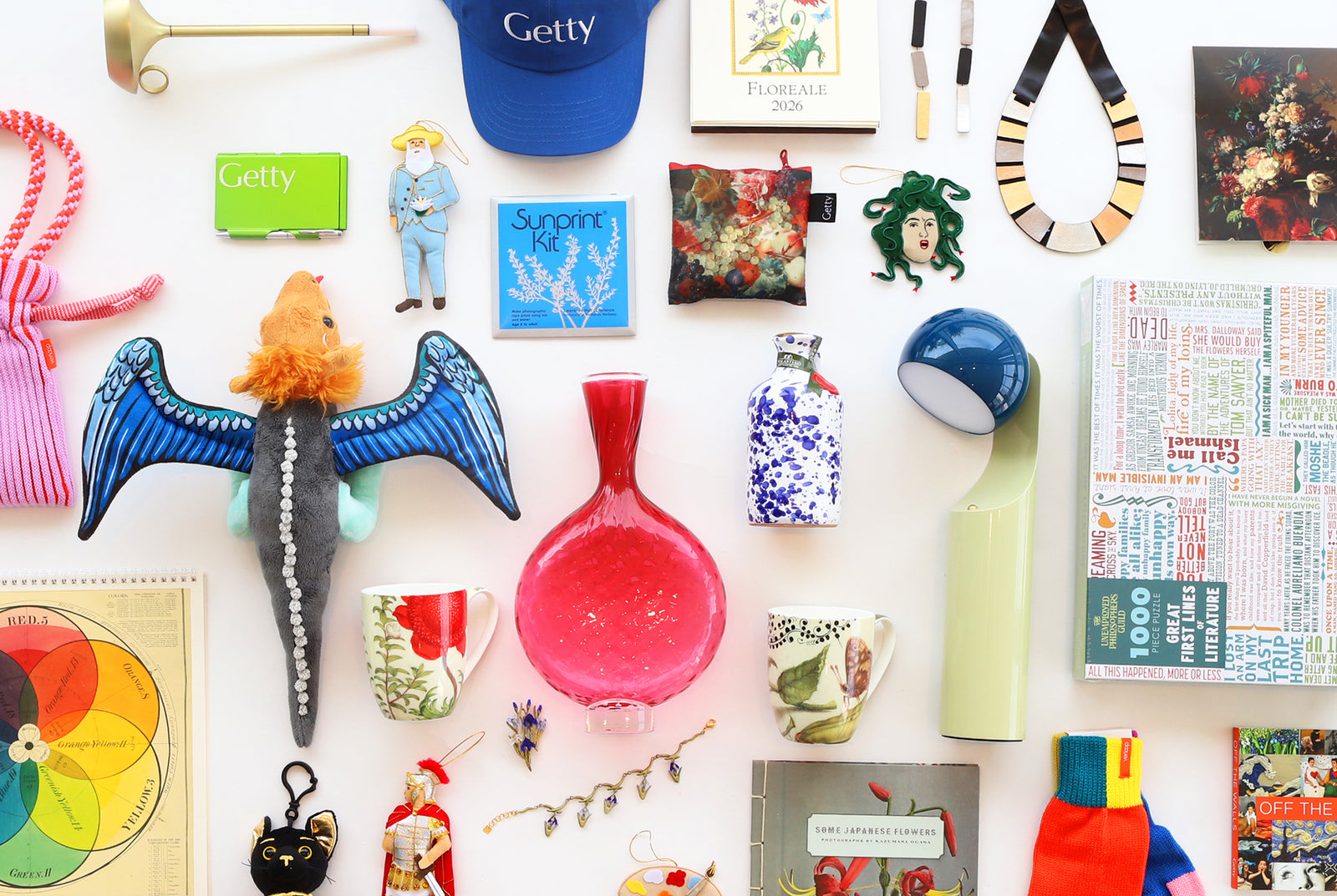 Collection of various small items including a blue cap, figurines, and decorative objects on a white surface.