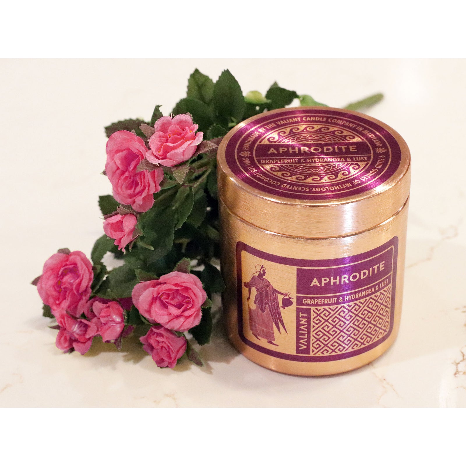 Gold color candle canister with purple graphics that read Aphrodite, Grapefruit & Hydrangea & Lust