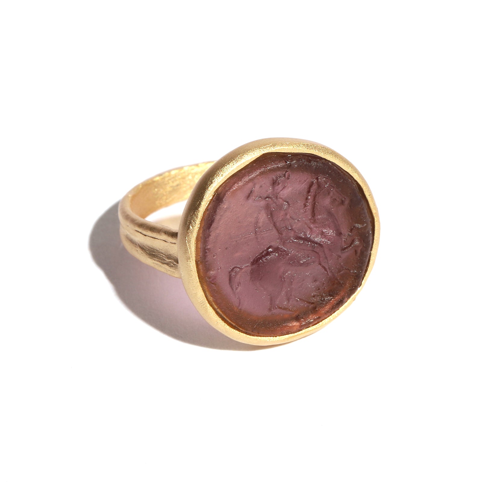 Gold ring with a purple figure on a white background