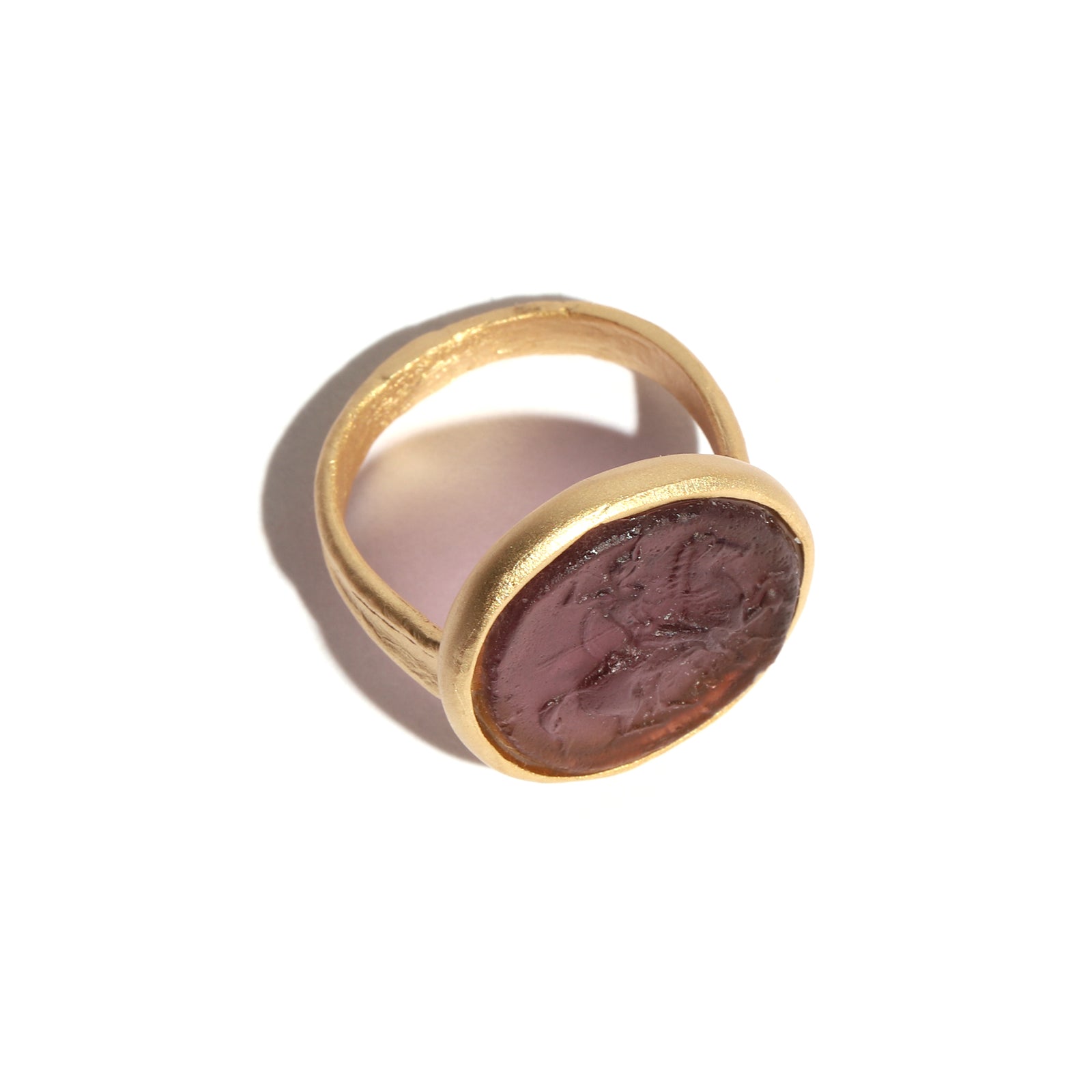 Gold ring with a purple figure on a white background