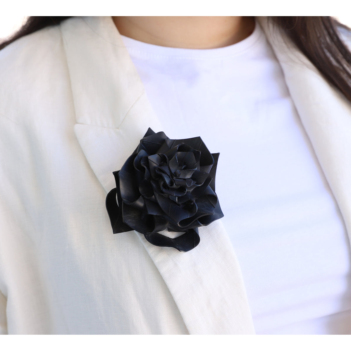 Black flower brooch on a white blazer