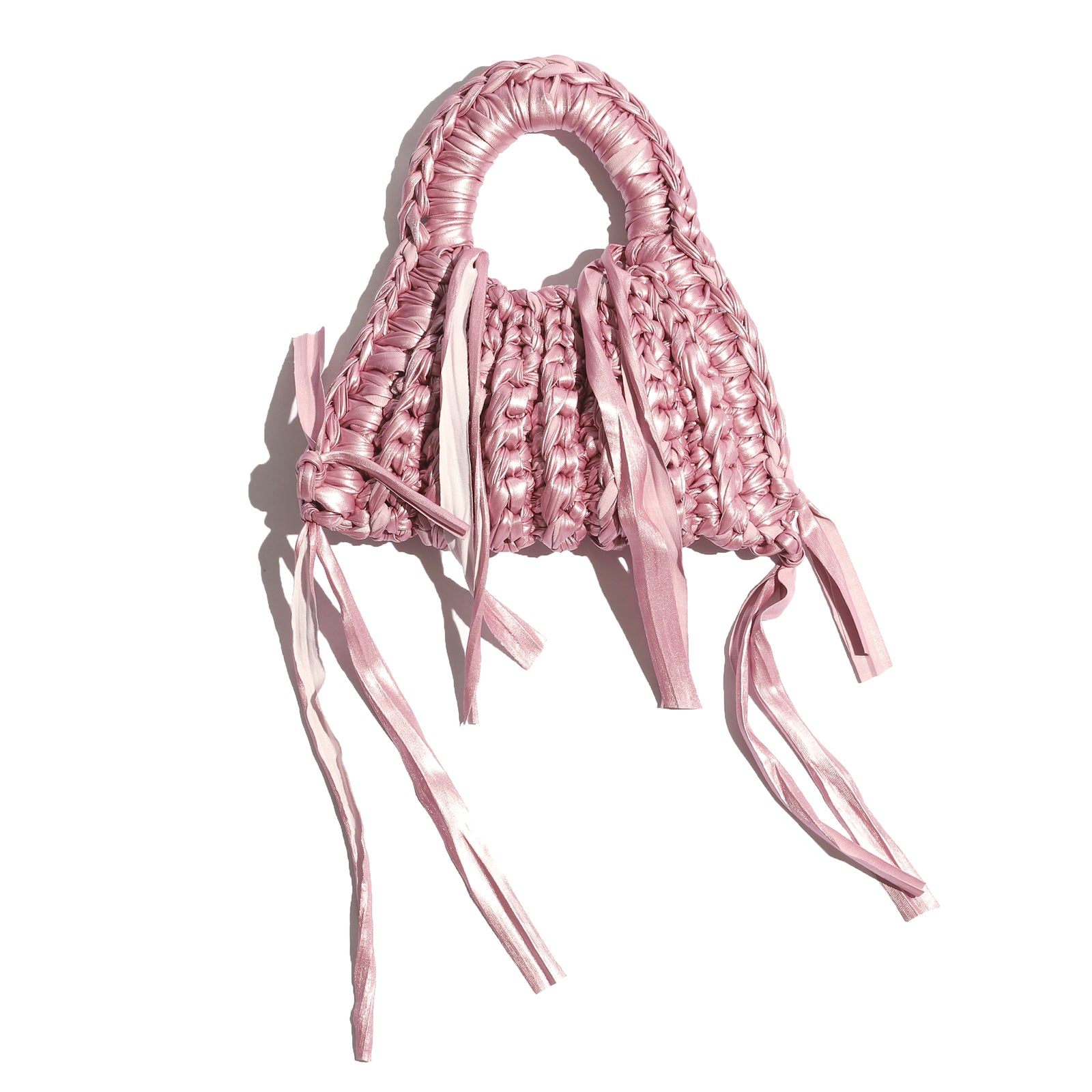 Pink woven handbag with fringes on a white background