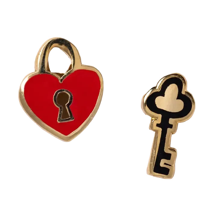 Red heart-shaped lock with a keyhole and a black and gold key on a white background