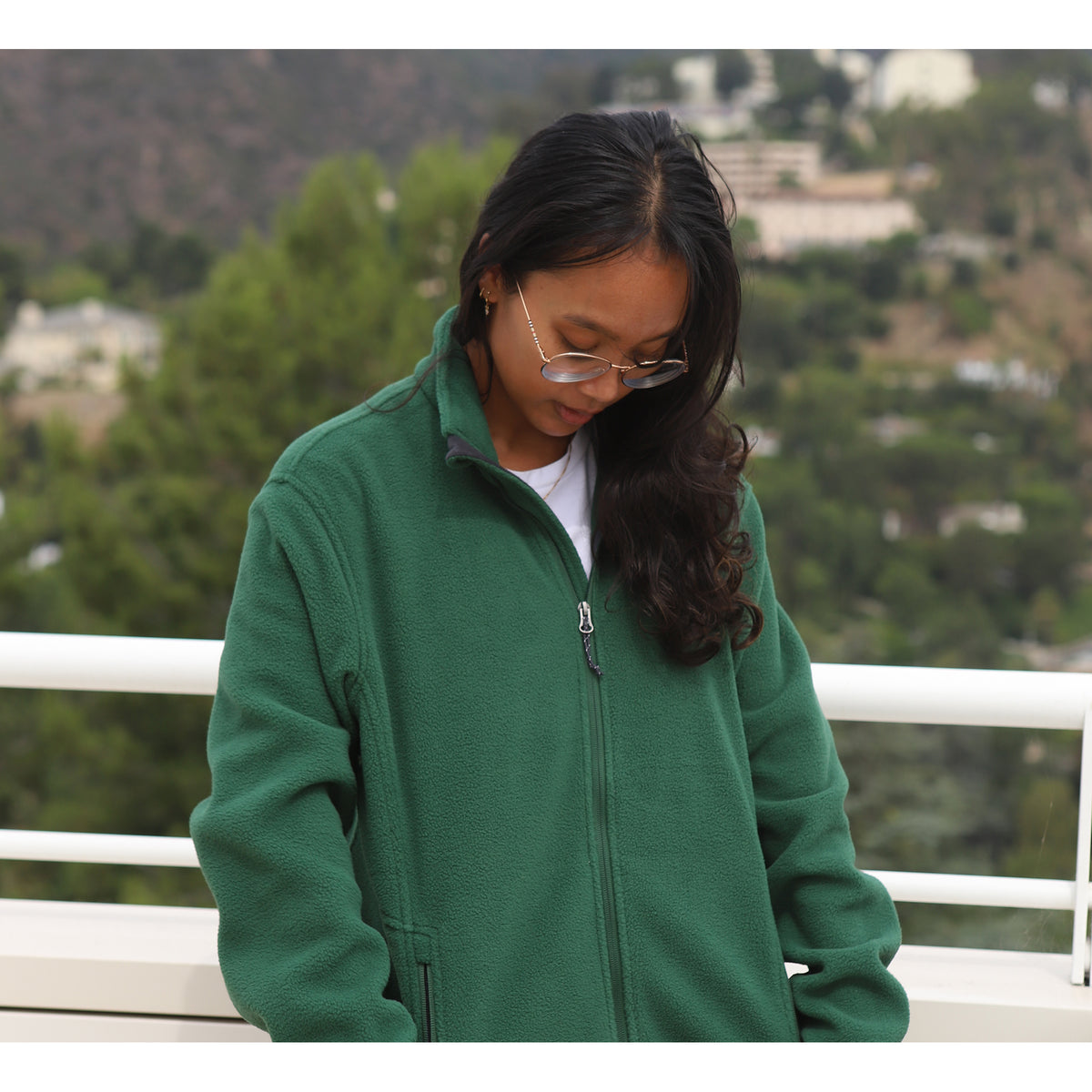 Person wearing a green jacket with a scenic background