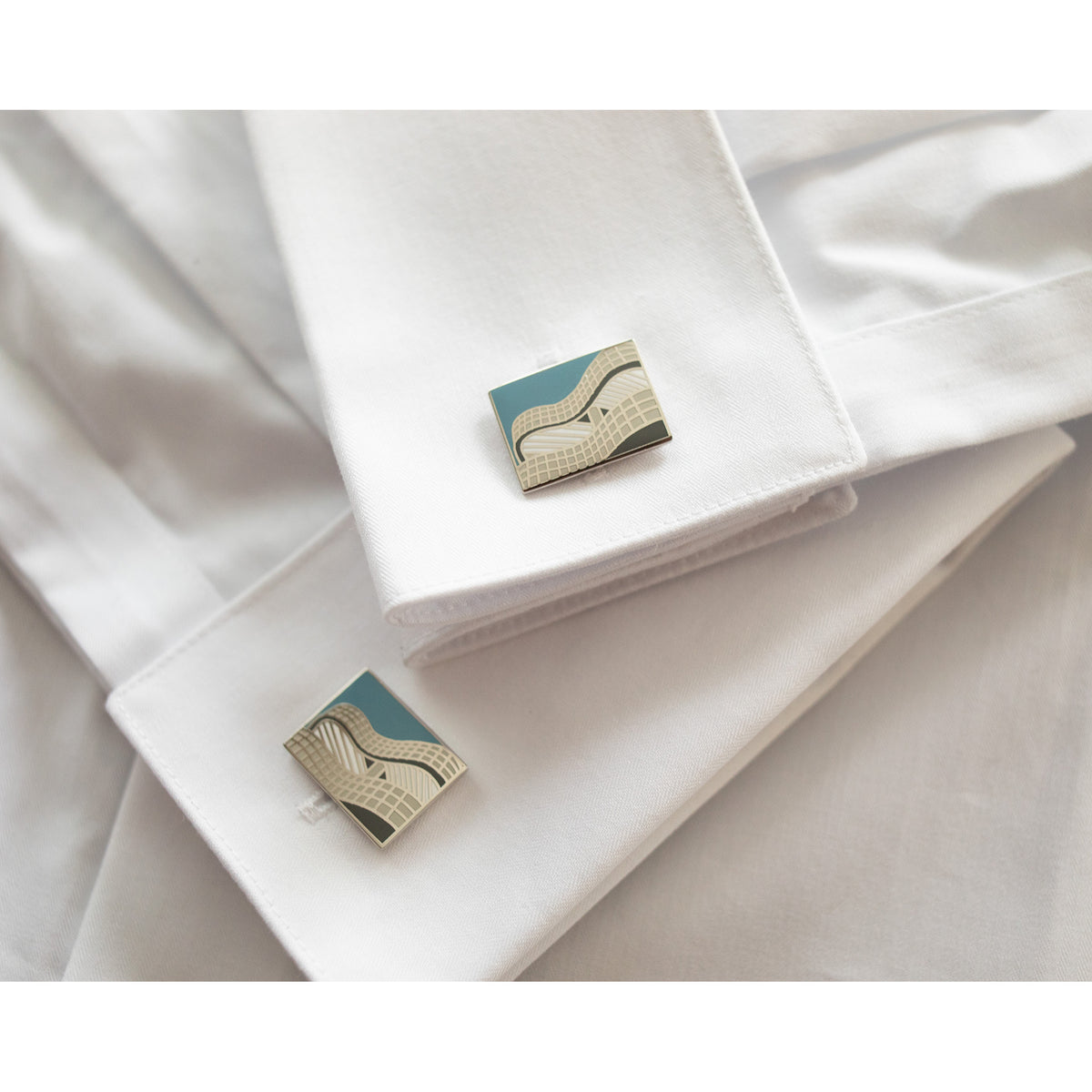 Cufflinks on a white shirt cuff with a neutral background