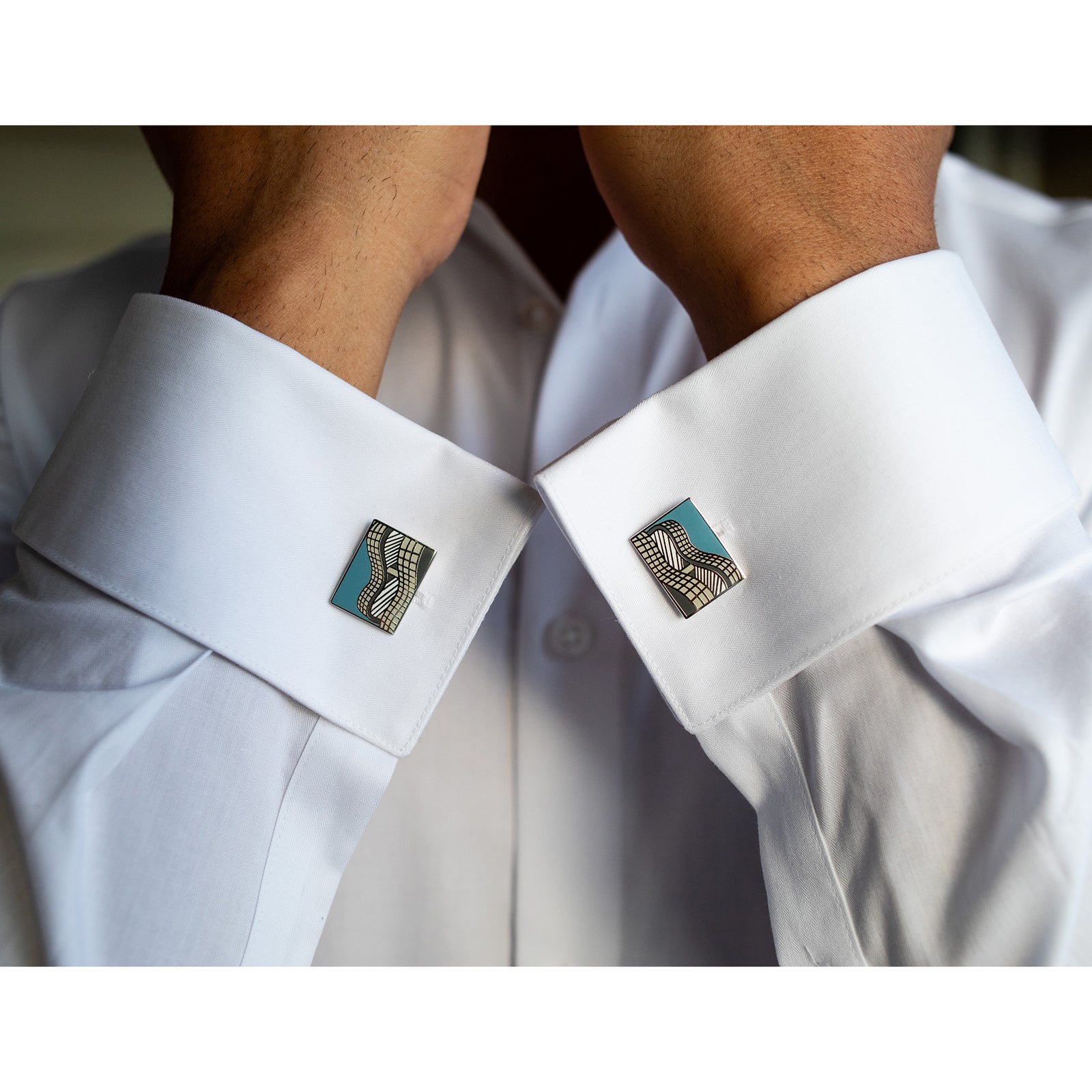 Pair of cufflinks with blue and silver design on a white background