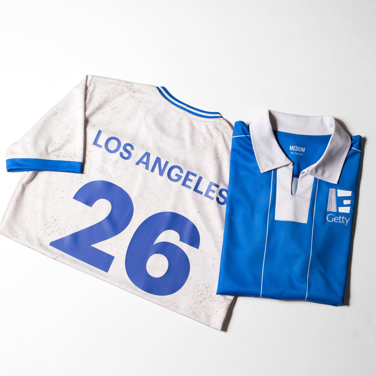 White and blue sports jersey with 'Los Angeles 26' printed on it, folded neatly.